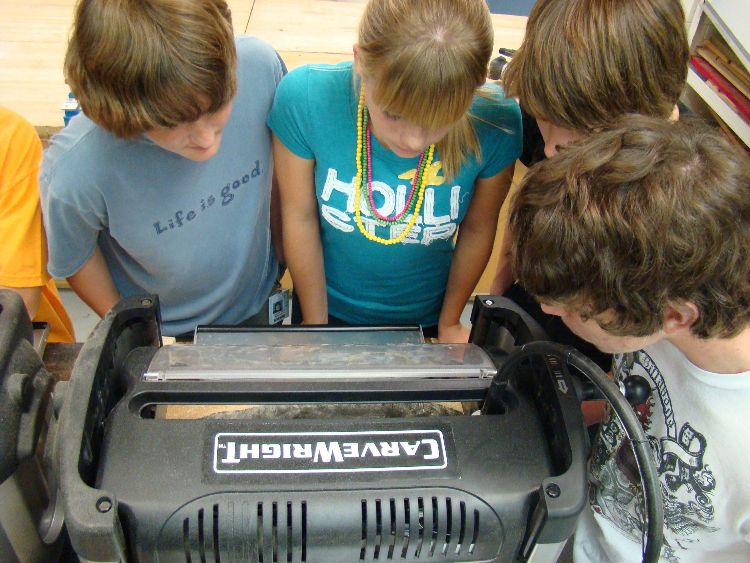 High school kids watching a CarveWright CNC machine carving